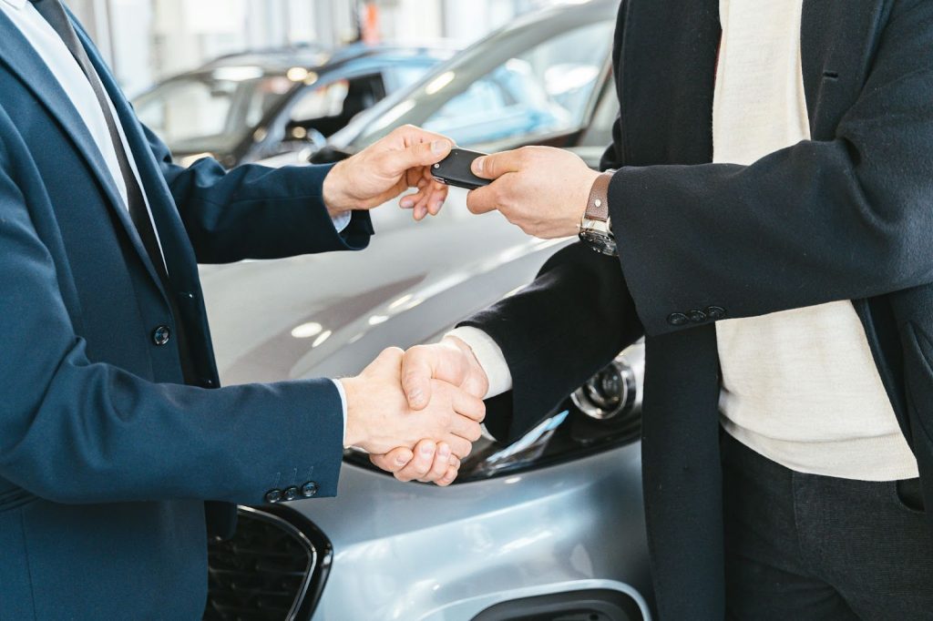 Dealer shaking hands with a customer that purchase a car
